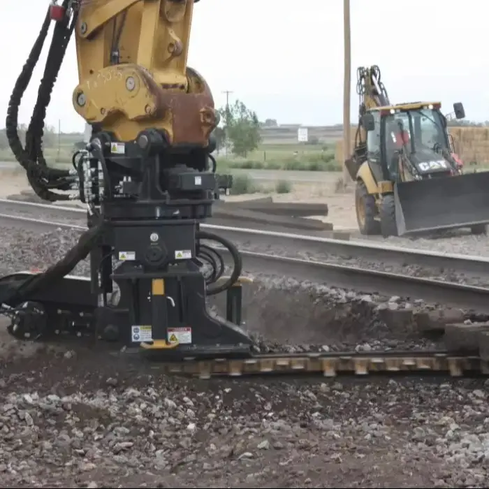 Railway excavator with ballast undercutter removes fouled ballast from underneath the railway track